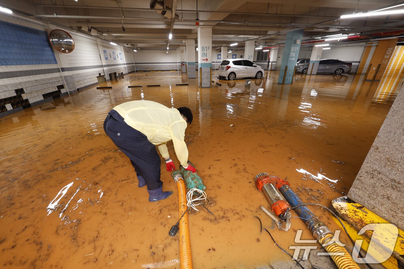 본문 이미지 - 4일 전남 무안군 무안읍 한 아파트 주차장에는 전날 내린 폭우로 주민 등이 흙탕물을 퍼내고 있다. ⓒ News1 김태성 기자