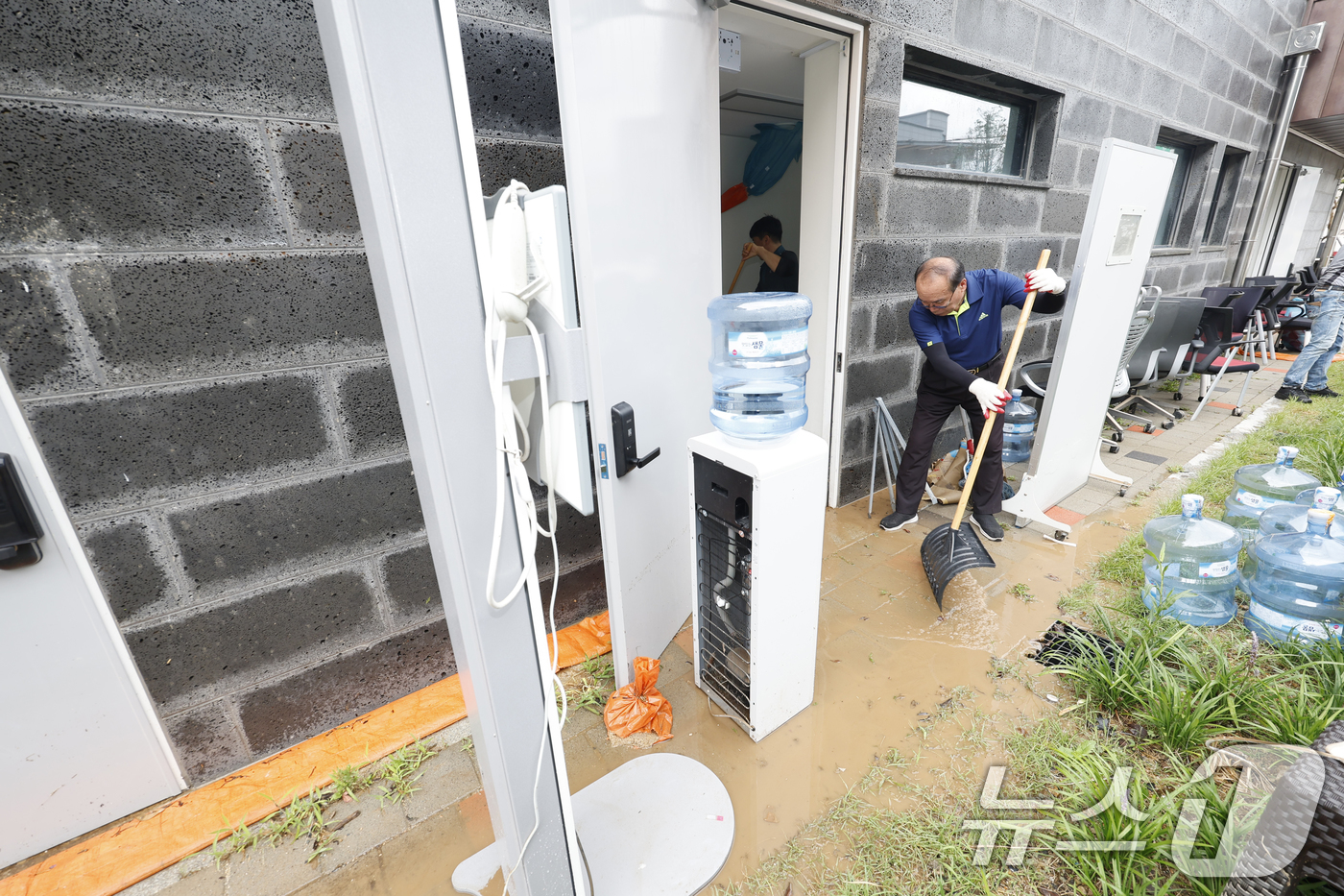 (무안=뉴스1) 김태성 기자 = 4일 전남 무안군 무안보건소가 전날 내린  폭우로 선별진료소 사무실이 잠겨 직원들이 흙탕물을 퍼내고 있다. 2025.8.4/뉴스1