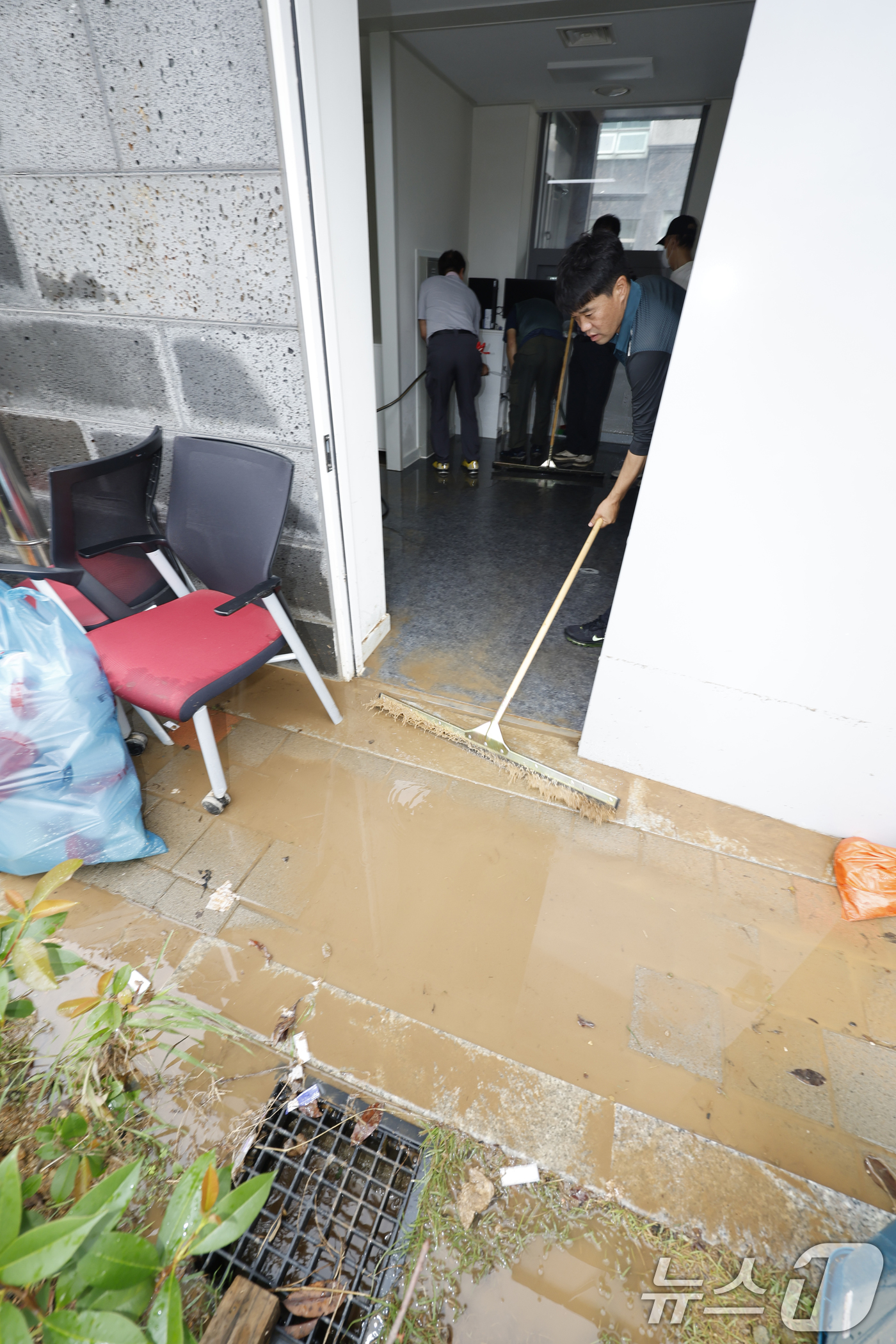 (무안=뉴스1) 김태성 기자 = 4일 전남 무안군 무안보건소가 전날 내린  폭우로 선별진료소 사무실이 잠겨 직원들이 흙탕물을 퍼내고 있다. 2025.8.4/뉴스1