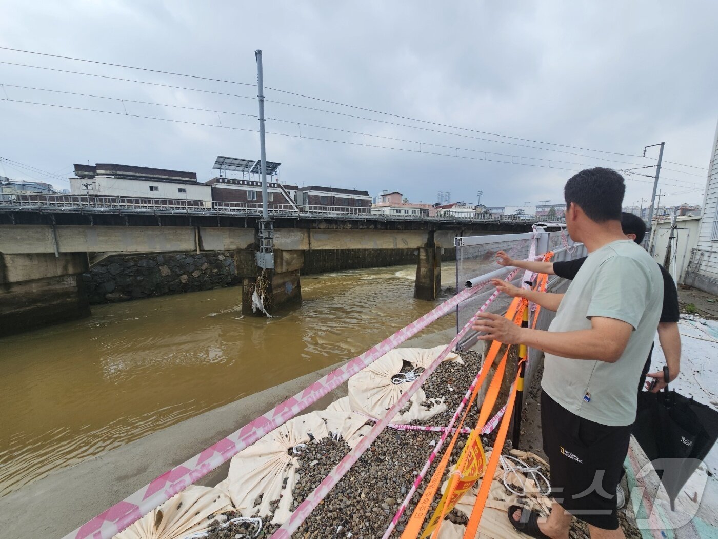본문 이미지 - 광주 북구 신안동 주민들이 4일 극한호우마다 침수 피해를 되풀이하는 서방천 내수벽을 바라보고 있다. 2025.8.4/뉴스1 ⓒ News1 최성국 기자