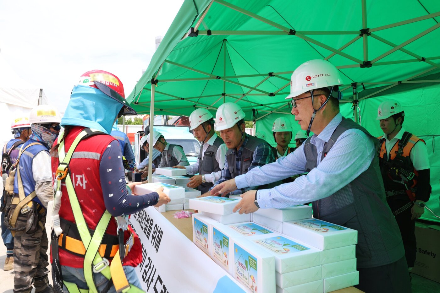 본문 이미지 - 박현철 롯데건설 부회장(앞줄 오른쪽)이 대구 '타임빌라스 수성' 현장에서 근로자들에게 아이스크림 츄러스와 이온음료, 혹서기 용품 등을 나눠주고 있다. /롯데건설 제공