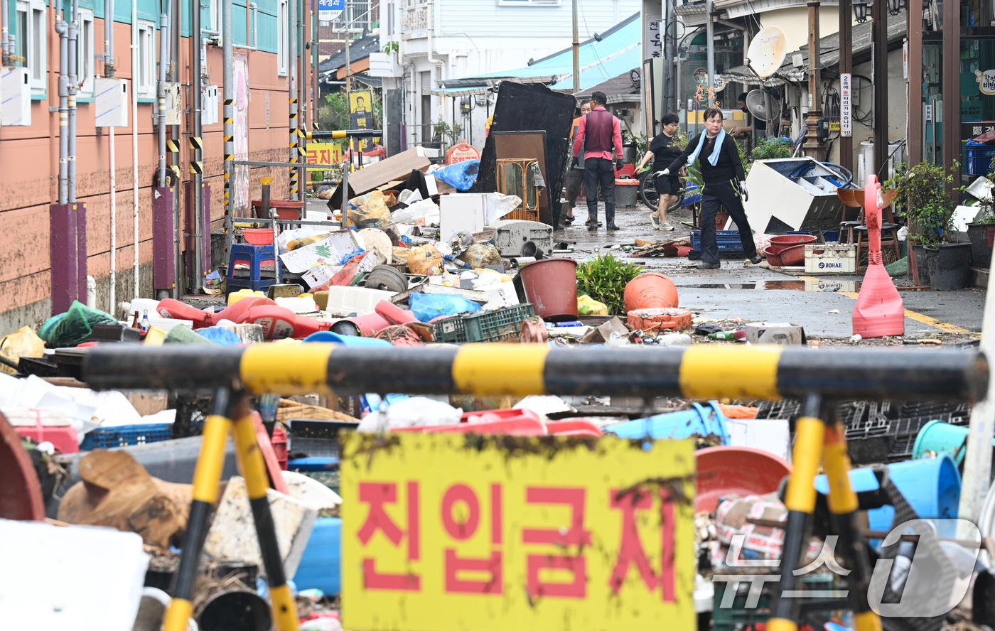 (함평=뉴스1) 김태성 기자 = 4일 전남 함평군 함평읍 천지전통시장에서 상인들이 폭우에 떠내려 온 각종 폐기물과 침수피해 입은 가재도구를 정리하고 있다. 2025.8.4/뉴스1