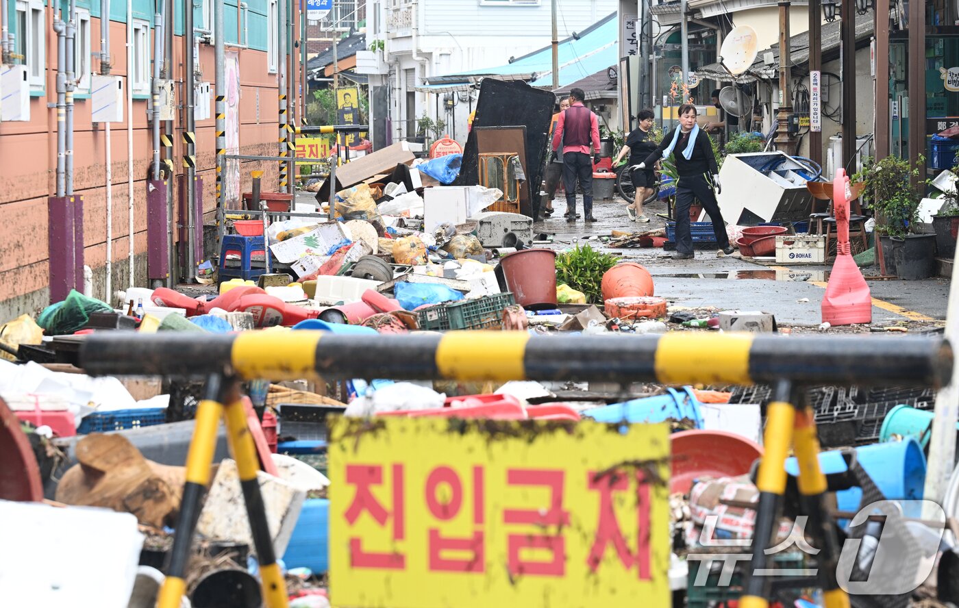 본문 이미지 - 4일 전남 함평군 함평읍 천지전통시장에서 상인들이 폭우에 떠내려 온 각종 폐기물과 침수피해 입은 가재도구를 정리하고 있다. 2025.8.4/뉴스1 ⓒ News1 김태성 기자