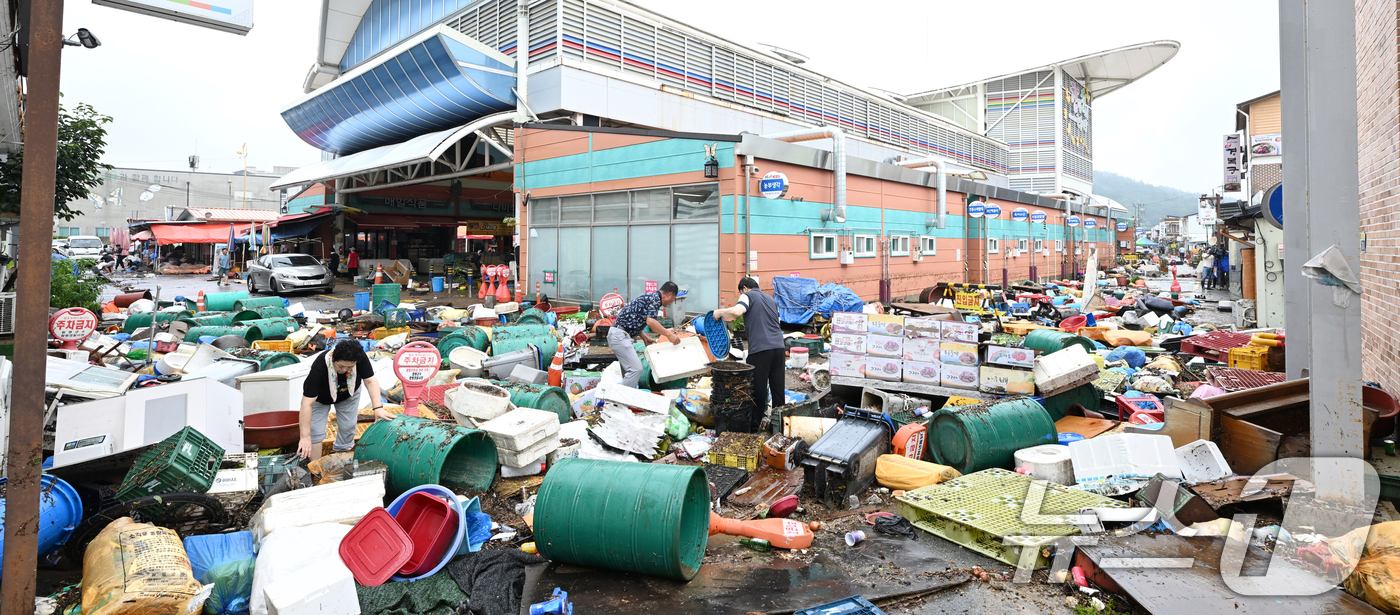 (함평=뉴스1) 김태성 기자 = 4일 전남 함평군 함평읍 천지전통시장에서 상인들이 폭우에 떠내려 온 각종 폐기물과 침수피해 입은 가재도구를 정리하고 있다. 2025.8.4/뉴스1