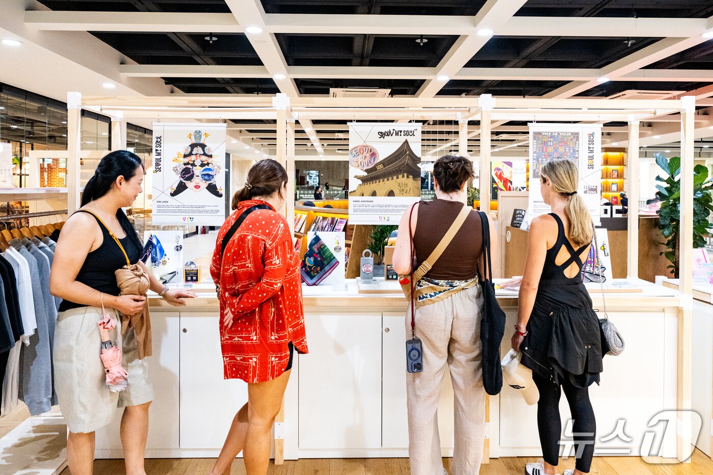 본문 이미지 - 서울마이소울샵 세종문화회관점에서 신규 아트콜라보 상품을 구경하는 외국인 방문객들&#40;서울관광재단 제공&#41;