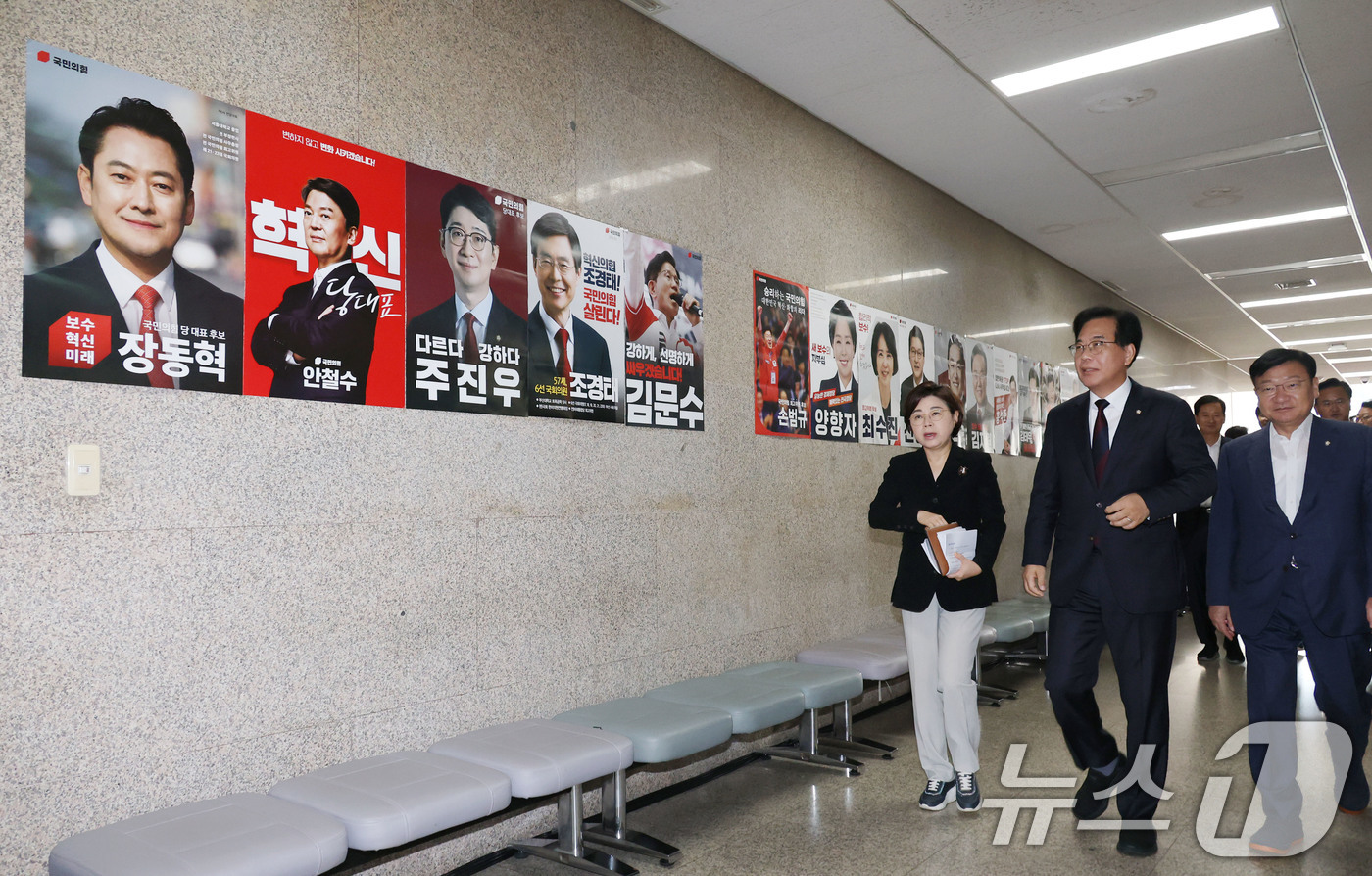 (서울=뉴스1) 이광호 기자 = 송언석 국민의힘 비상대책위원장 겸 원내대표가 5일 오전 서울 여의도 국회 본청 복도에 붙은 당대표 후보자들의 포스터를 바라보며 원내대책회의에 참석하 …
