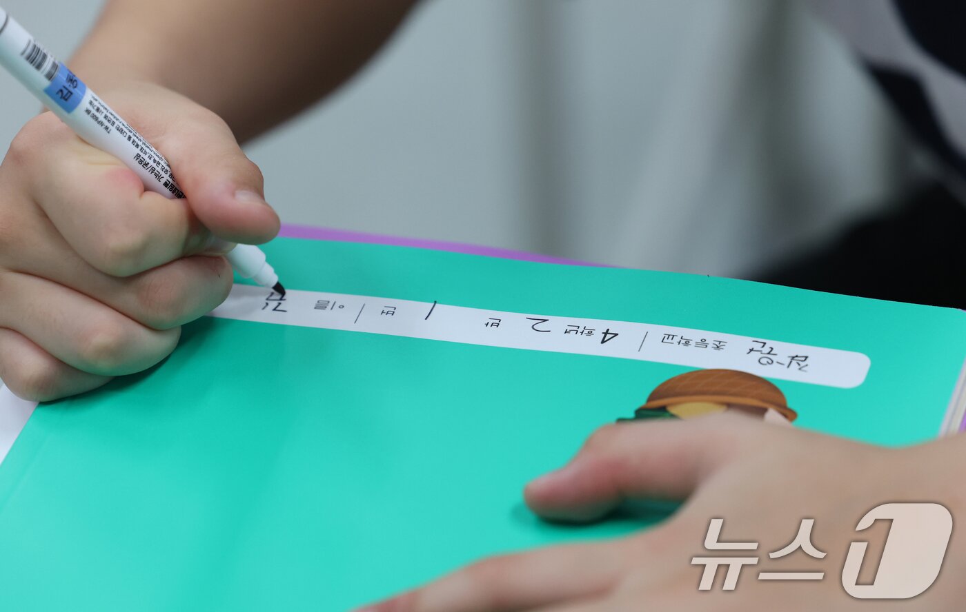 본문 이미지 - 5일 오전 여름방학을 마치고 개학한 경기 수원시 영통구 잠원초등학교에서 학생들이 새학기 교과서에 이름을 쓰고 있다. 2025.8.5/뉴스1 ⓒ News1 김영운 기자