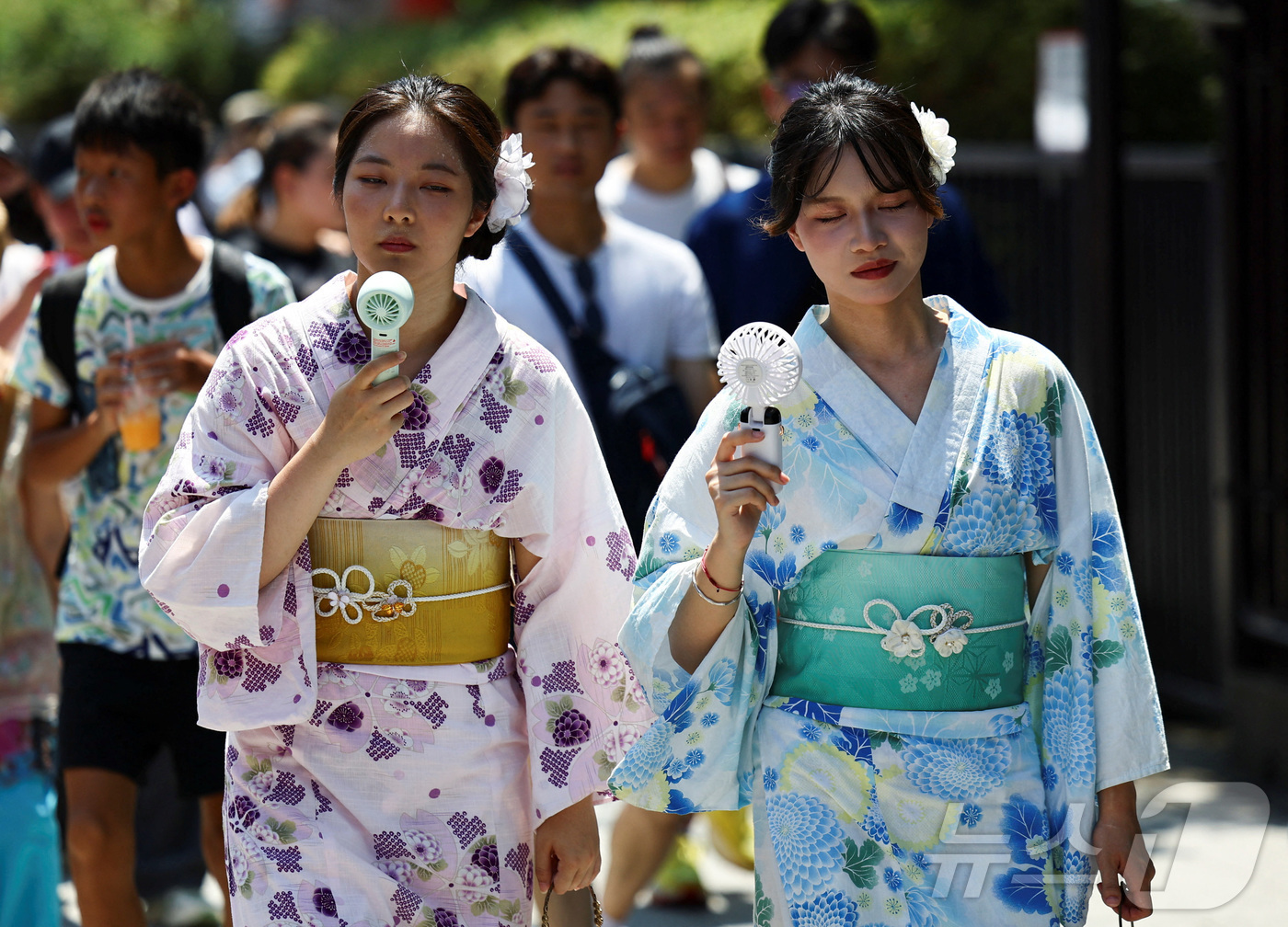 (도쿄 로이터=뉴스1) 최종일 선임기자 = 5일 일본 도쿄 아카쿠사에서 유카타를 입은 여성들이 휴대용 선풍기로 땀을 식히고 있다. 이날 오후, 도쿄도 오메시는 40.3도를 기록했다 …