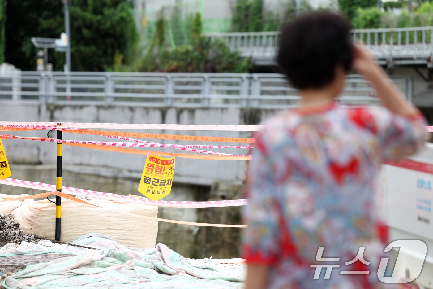 본문 이미지 - 이틀간 최대 120㎜의 비가 예보된 6일 오전 광주 북구 신안동에서 침수 피해를 입은 주민이 홍수 방어벽을 바라보고 있다. 2025.8.6/뉴스1 ⓒ News1 이승현 기자