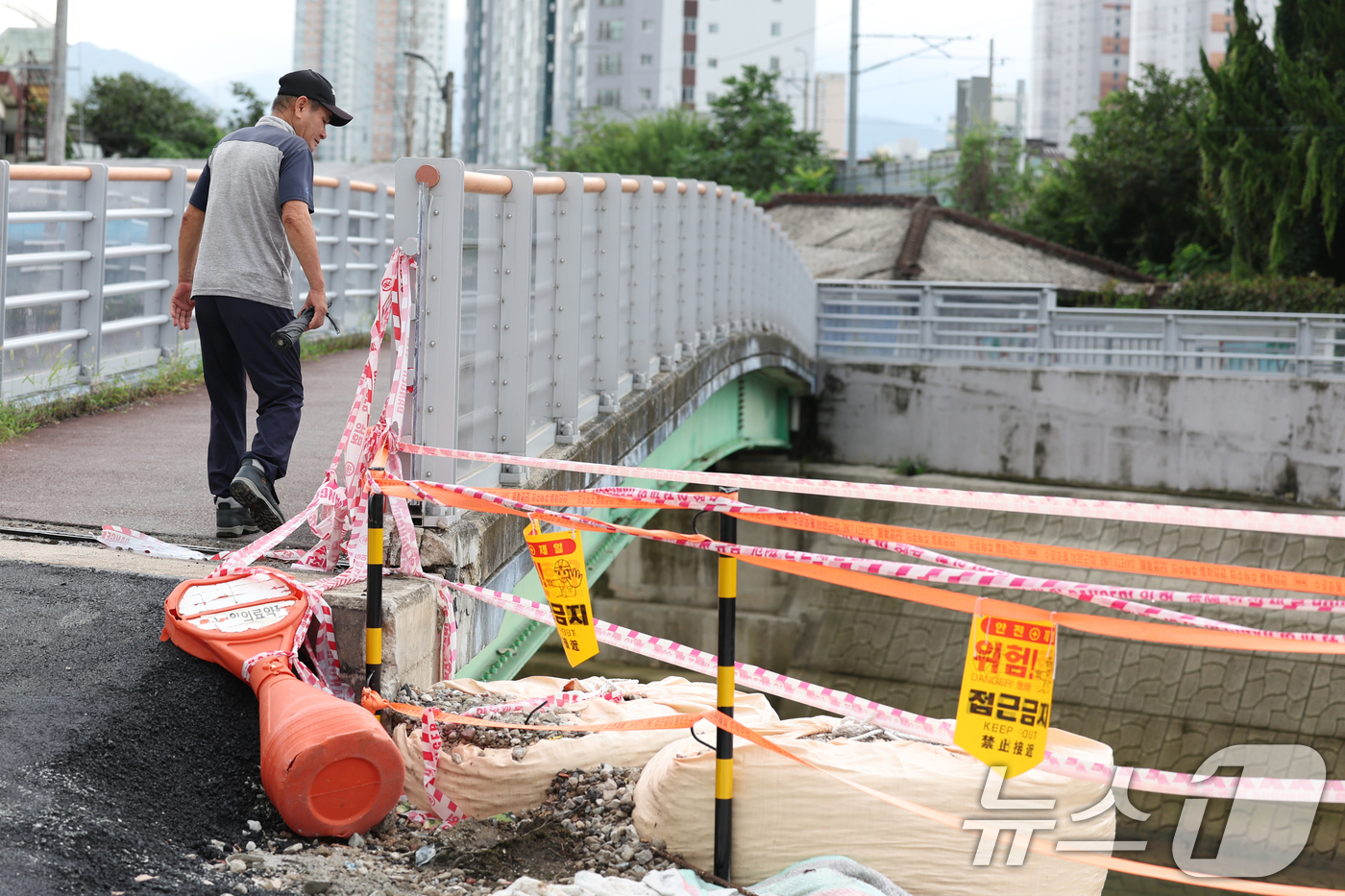(광주=뉴스1) 이승현 기자 = 이틀간 최대 120㎜의 비가 예보된 6일 오전 광주 북구 신안동에서 한 주민이 무너진 홍수 방어벽을 바라보고 있다.  2025.8.6/뉴스1