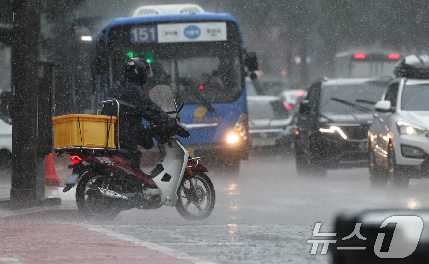 본문 이미지 - 서울 등 수도권과 충청지역에 호우 예비특보가 내려진 6일 오후 서울 종로 거리 일대에서 한 라이더가 오토바이를 끌고 신호를 기다리고 있다. 2025.8.6/뉴스1 ⓒ News1 구윤성 기자