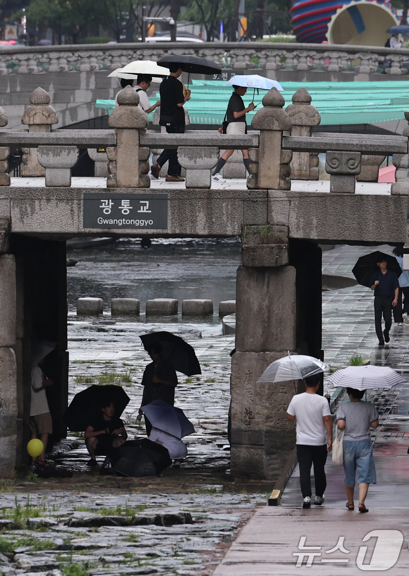 (서울=뉴스1) 구윤성 기자 = 서울 등 수도권과 충청지역에 호우 예비특보가 내려진 6일 오후 서울 청계천 광통교 아래에서 시민들이 내리는 비를 피하고 있다. 2025.8.6/뉴스 …