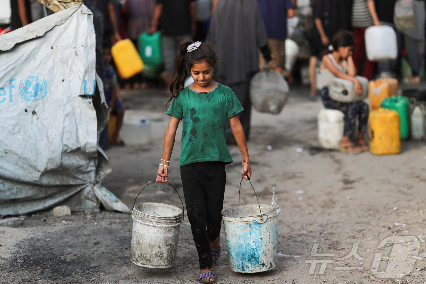 (가자시티 로이터=뉴스1) 권영미 기자 = 극심한 물 부족을 겪고 있는 가자시티에서 6일(현지시간) 한 소녀가 양동이를 들고 걷고 있다. 2025.08.06.ⓒ 로이터=뉴스1
