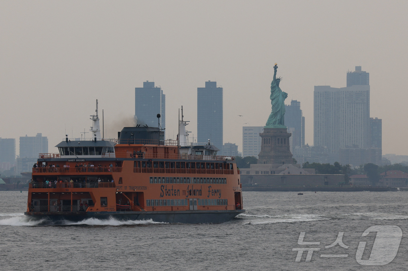 (뉴욕 로이터=뉴스1) 권영미 기자 = 5일(현지시간) 캐나다 산불로 인한 연기와 안개가 미국 뉴욕시와 뉴저지 상공에 자욱한 가운데, 스태튼 아일랜드 페리가 자유의 여신상 앞을 지 …