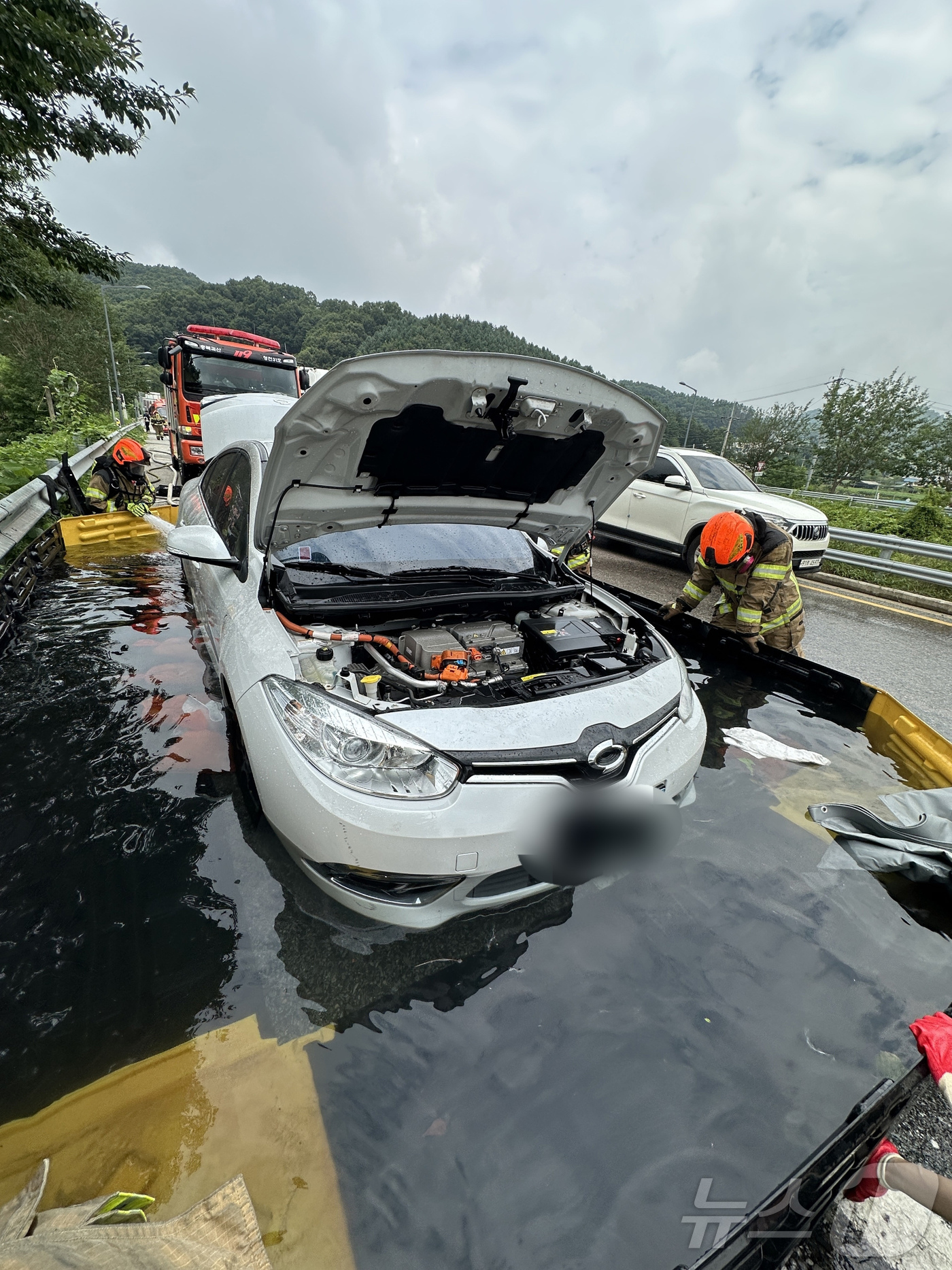 (청주=뉴스1) = 7일 오전 8시54분께 충북 괴산군 문광면 문법리 유평터널 인근에서 전기차에 화재가 발생해 소방당국이 이동형 수조를 이용해 화재를 진압하고 있다.(괴산소방서 제 …