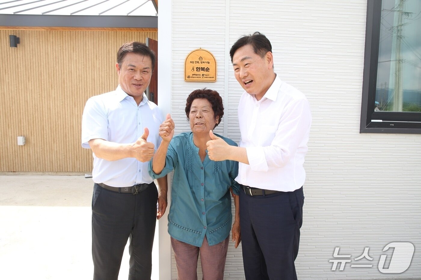 본문 이미지 - 7일 정읍시 소성면 금동마을에서 산불피해 이재민 보금자리 입주식 기념 행사가 개최된 가운데 김관영 전북도지사&#40;오른쪽&#41;와 이학수 정읍시장&#40;왼쪽&#41;이 입주민과 문패을 달고 기념 촬영을 하고 있다.&#40;정읍시 제공. 재판매 및 DB금지&#41;/뉴스1