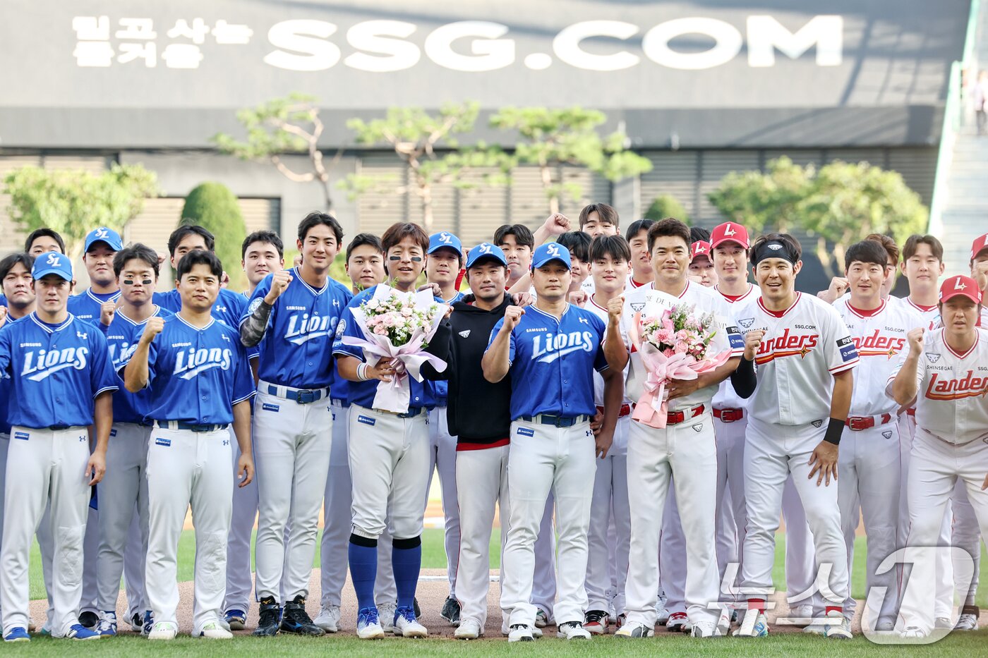 본문 이미지 - 전격 은퇴를 선언한 삼성 오승환이 7일 오후 인천 미추홀구 SSG랜더스필드에서 열린 은퇴 기념행사에서 SSG 김광현으로부터 꽃다발을 선물 받은 뒤 양팀 선수들과 함께 기념촬영을 하고 있다. 2025.8.7/뉴스1 ⓒ News1 민경석 기자