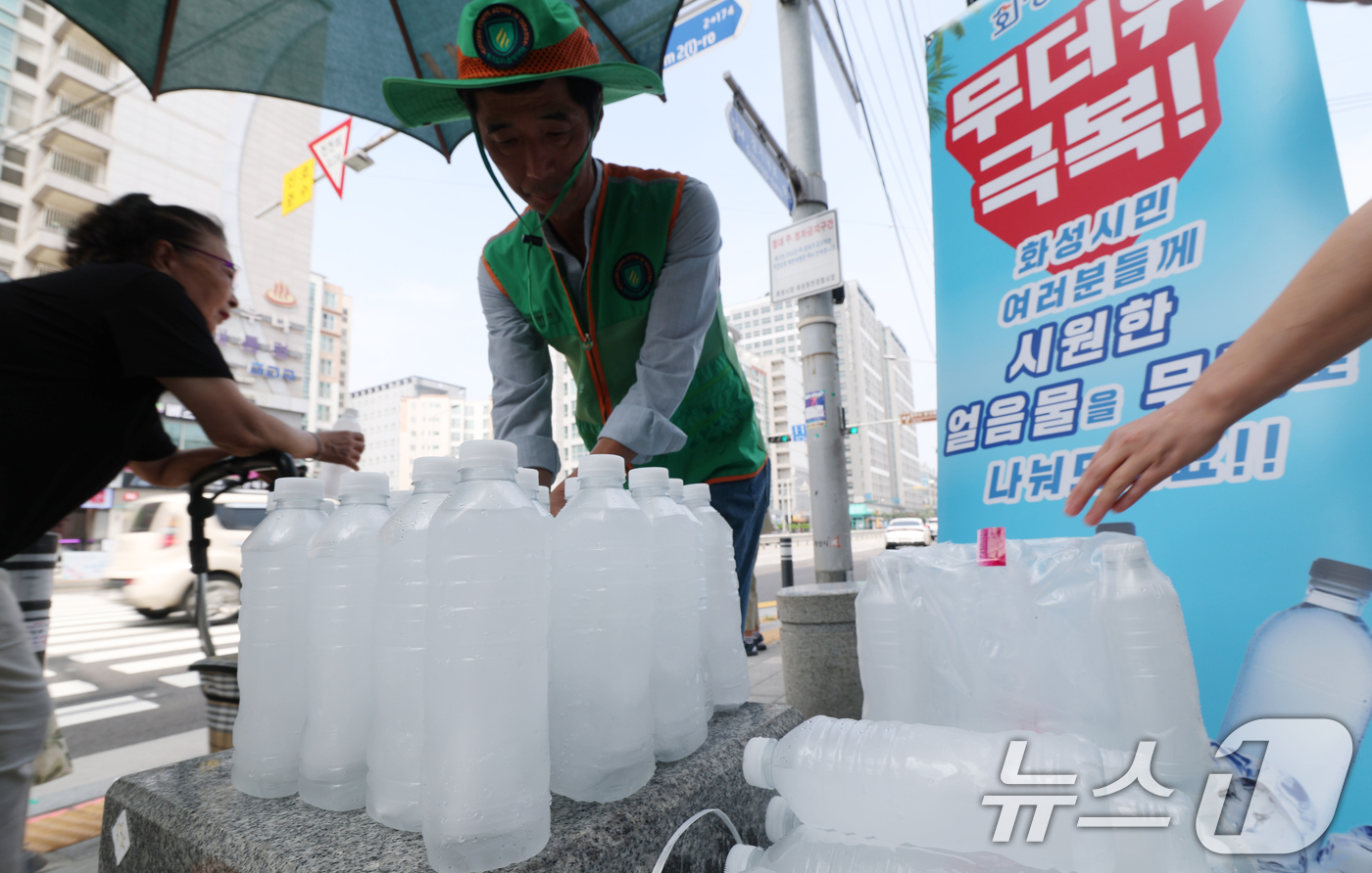 (화성=뉴스1) 김영운 기자 = 말복을 하루 앞둔 8일 경기 화성시의 한 거리에서 화성시 자율방재단이 시민들에게 얼음물을 나눠주고 있다.화성시의 얼음물 나눔 사업은 폭염이 누그러지 …