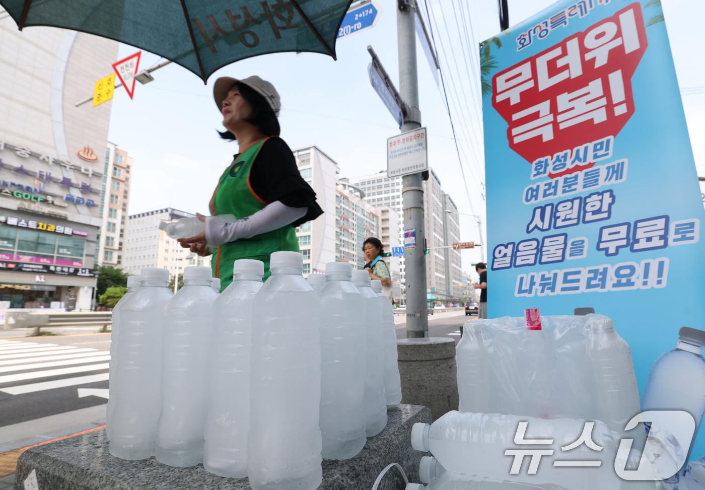 (화성=뉴스1) 김영운 기자 = 말복을 하루 앞둔 8일 경기 화성시의 한 거리에서 화성시 자율방재단이 시민들에게 얼음물을 나눠주고 있다.화성시의 얼음물 나눔 사업은 폭염이 누그러지 …