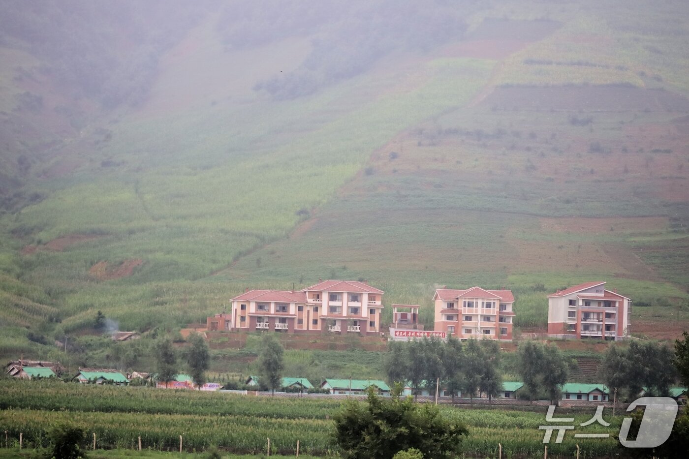 본문 이미지 - 하중도인 벌등도 너머로 보이는 자강도 만포시 압록강 연안의 마을 모습. 지난해 홍수피해를 입은 후 새로 지어진 주택들이다. &#40;평화경제연구소 제공&#41; 