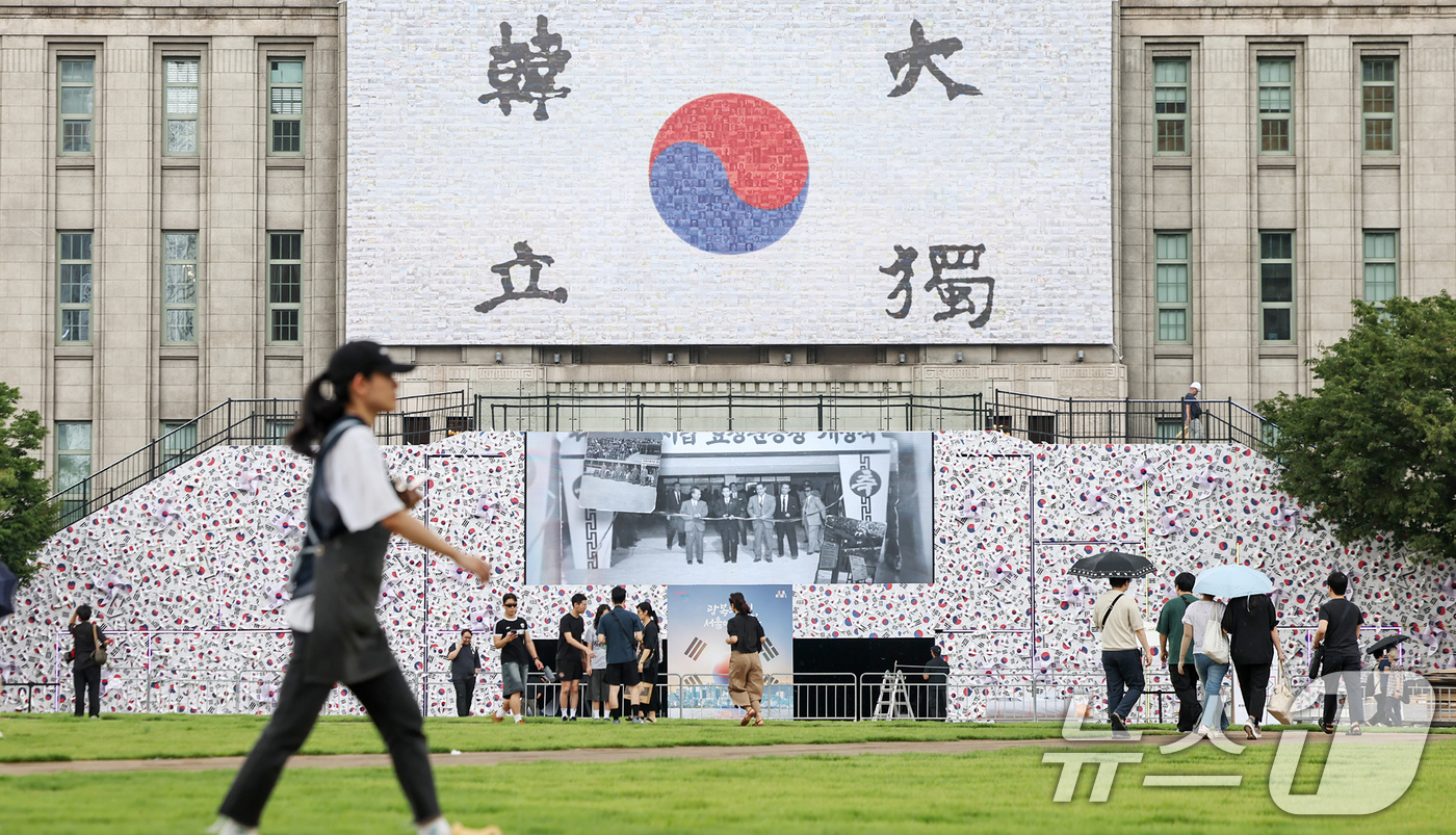 (서울=뉴스1) 민경석 기자 = 8일 오후 서울 중구 서울도서관 앞에 광복 80주년을 맞아 설치된 '태극기 언덕' 앞으로 시민들이 오가고 있다. 2025.8.8/뉴스1