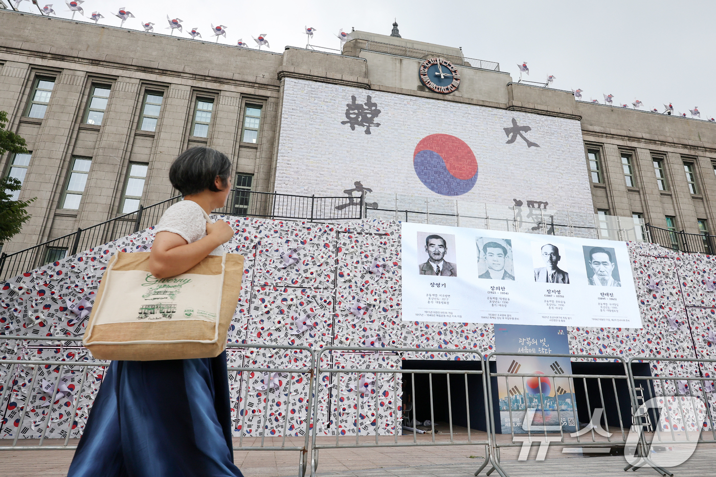 (서울=뉴스1) 민경석 기자 = 8일 오후 서울 중구 서울도서관 앞에 광복 80주년을 맞아 설치된 '태극기 언덕' 앞으로 시민들이 오가고 있다. 2025.8.8/뉴스1
