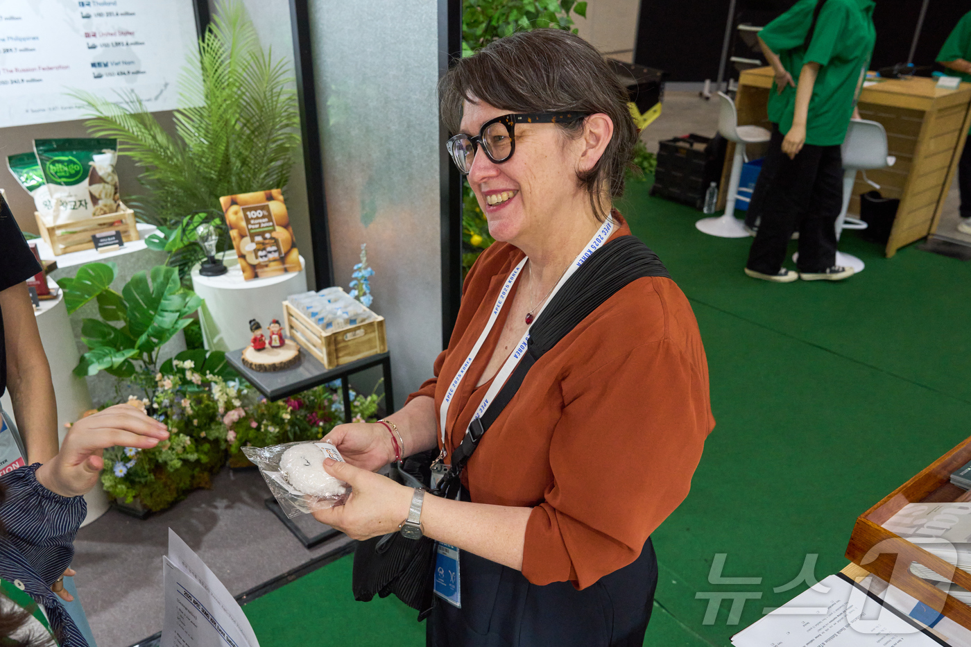 (서울=뉴스1) = 8일 인천 송도 컨벤시아에 마련된 한식 다과 홍보존을 찾은 APEC 참석자가 전시를 둘러본 후 한식진흥원 캐릭터 '밥돌이' 기념품을 수령하고 있다. (한식진흥원 …