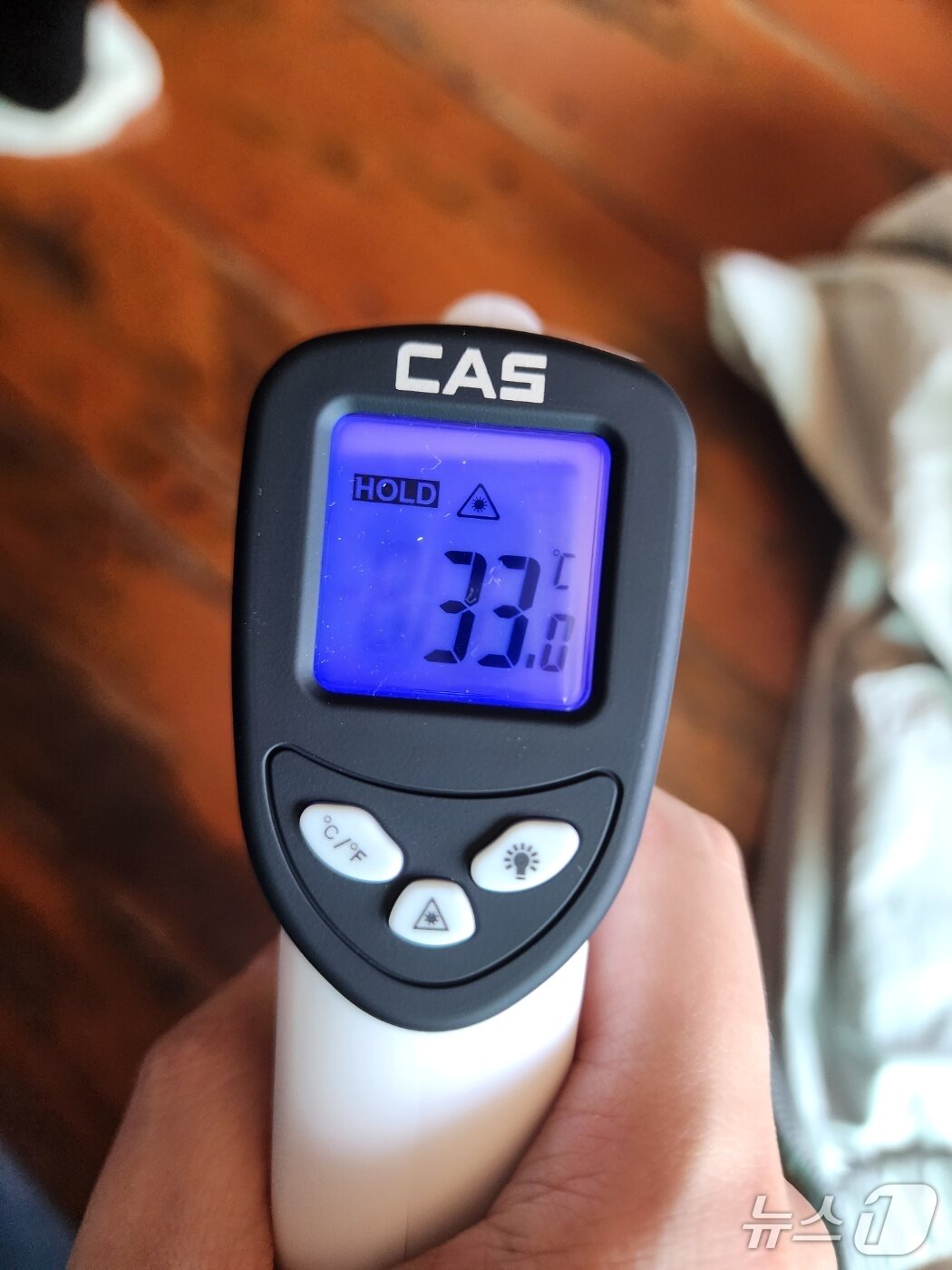 본문 이미지 - 7일 경기도 양평 소재 이 할머니 댁 현관 마루 표면 온도를 측정한 결과. 바로 앞에 선풍기가 돌아가고 있음에도 불구하고 섭씨 33도로 실외 온도보다 1도 높다.  2025.08.07/ⓒ 뉴스1