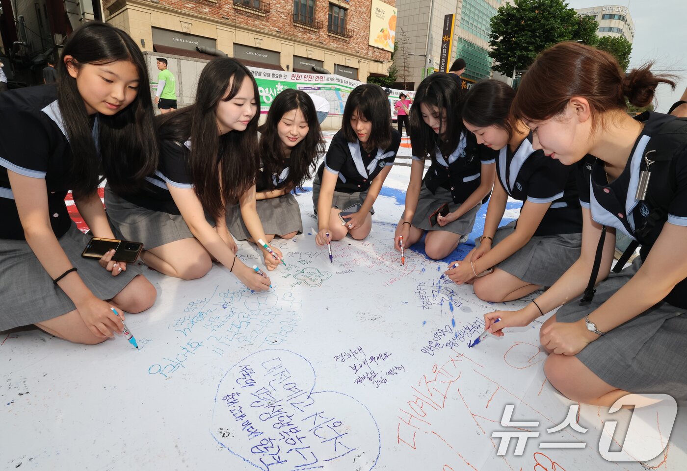 본문 이미지 - 대전0시축제가 개막한 8일 오후 중앙로 일원에서 학생들이 소망문구를 적고 있다. 2025.8.8/뉴스1 ⓒ News1 김기태 기자