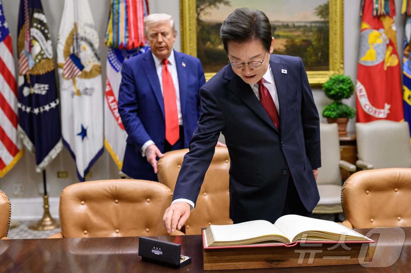 본문 이미지 - 지난 8월 25일&#40;현지시간&#41; 이재명 대통령이 한미정상회담에 앞서 미 백악관 루즈벨트룸에서 방명록에 서명하려고 펜을 잡으려는 순간 도널드 트럼프 미국 대통령이 뒤에서 의자를 당겨 주고 있다. &#40;백악관 제공. 재판매 및 DB금지&#41; 2025.9.1/뉴스1 ⓒ News1 류정민 특파원