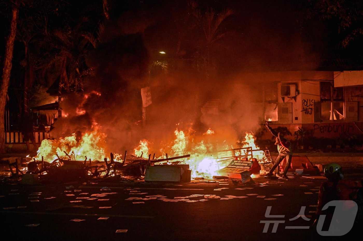 (수라바야 AFP=뉴스1) 김지완 기자 = 31일(현지시간) 인도네시아 자바섬 수라바야에서 열린 시위에 참석한 한 사람이 경찰청 본부를 향해 물건을 던지고 있다. 인도네시아에서는 …