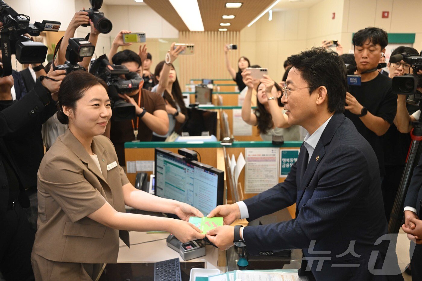 본문 이미지 - 권대영 금융위원회 부위원장이 1일 오전 서울 중구 하나은행 본점에서 열린 예금보호한도 1억원 시행 현장방문에서 예금상품 가입을 마친 뒤 직원으로부터 통장을 수령하고 있다. &#40;공동취재&#41; 2025.9.1/뉴스1 ⓒ News1 이광호 기자