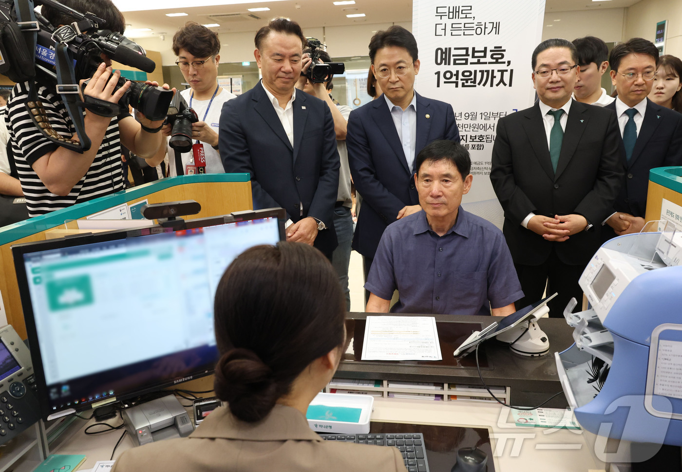 (서울=뉴스1) 이광호 기자 = 예금보호한도 1억원 시행  첫 날인 1일 오전 서울 중구 하나은행 본점 영업점을 찾은 고객이 예금상품에 가입하고 있다.뒷줄 왼쪽부터 유재훈 예금보험 …