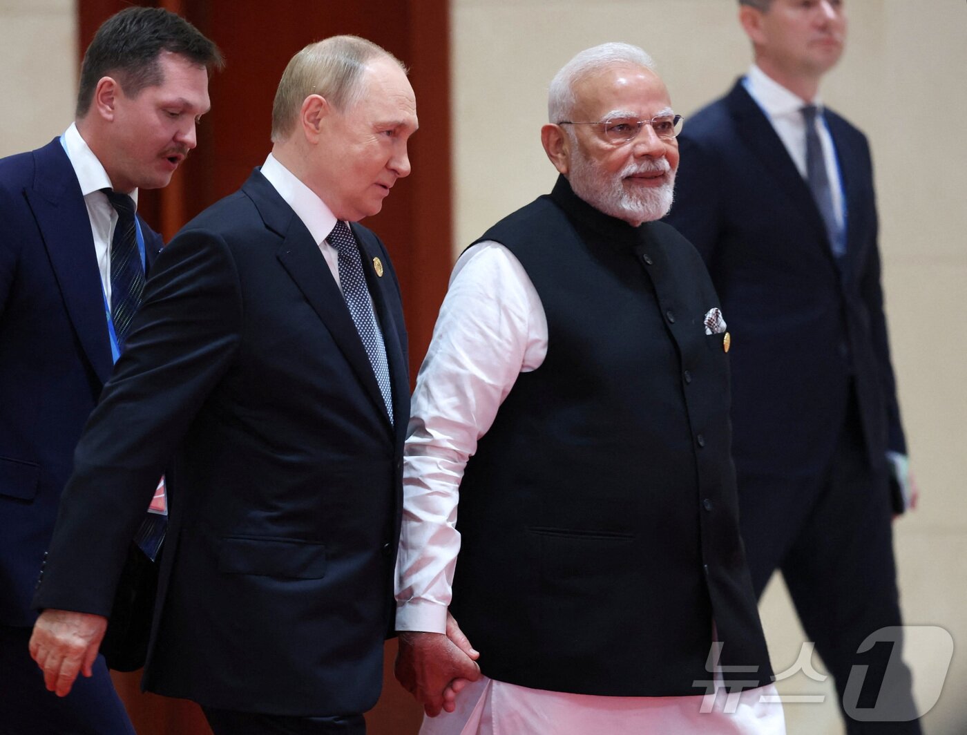 본문 이미지 - 블라디미르 푸틴 러시아 대통령&#40;왼쪽&#41;과 나렌드라 모디 인도 총리가 1일 중국 톈진에서 열린 상하이협력기구&#40;SCO&#41; 정상회의에서 손을 잡고 대화하며 이동하고 있다. 2025.09.01 ⓒ 로이터=뉴스1 ⓒ News1 이지예 객원기자
