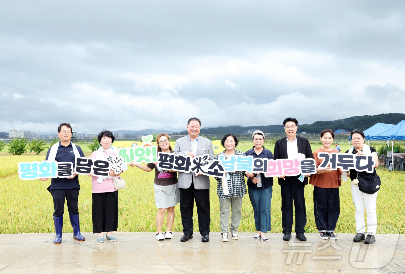 (서울=뉴스1) = 1일 파주시 장단면 평화농장에서 열린 '평원벼(평화米소) 벼베기 행사'에서 김경일 파주시장을 비롯한 참석자들이 기념 촬영을 하고 있다. (파주시청 제공. 재판매 …