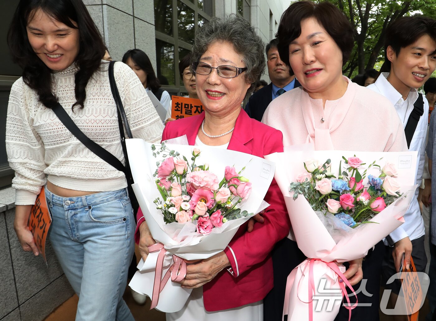 본문 이미지 - 61년 전 성폭행범 혀를 깨물어 집행유예 확정판결을 받았던 최말자 씨가 10일 오후 부산 연제구 부산지방법원에서 열린 재심 선고공판에서 무죄를 선고받은 뒤 법정을 나서며 참석자들과 기뻐하고 있다.  2025.9.10/뉴스1 ⓒ News1 윤일지 기자