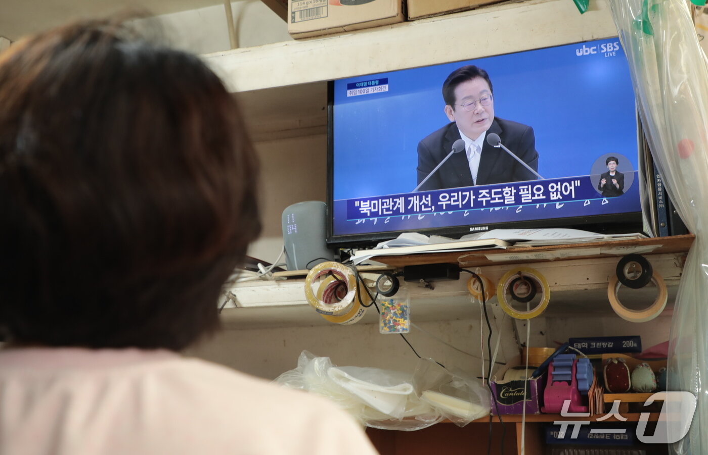 본문 이미지 - 울산 남구 신정시장에서 한 상인이 생중계로 이재명 대통령의 취임 100일 기념 기자회견을 시청하고 있다.2025.9.11./ⓒ 뉴스1 김세은 기자