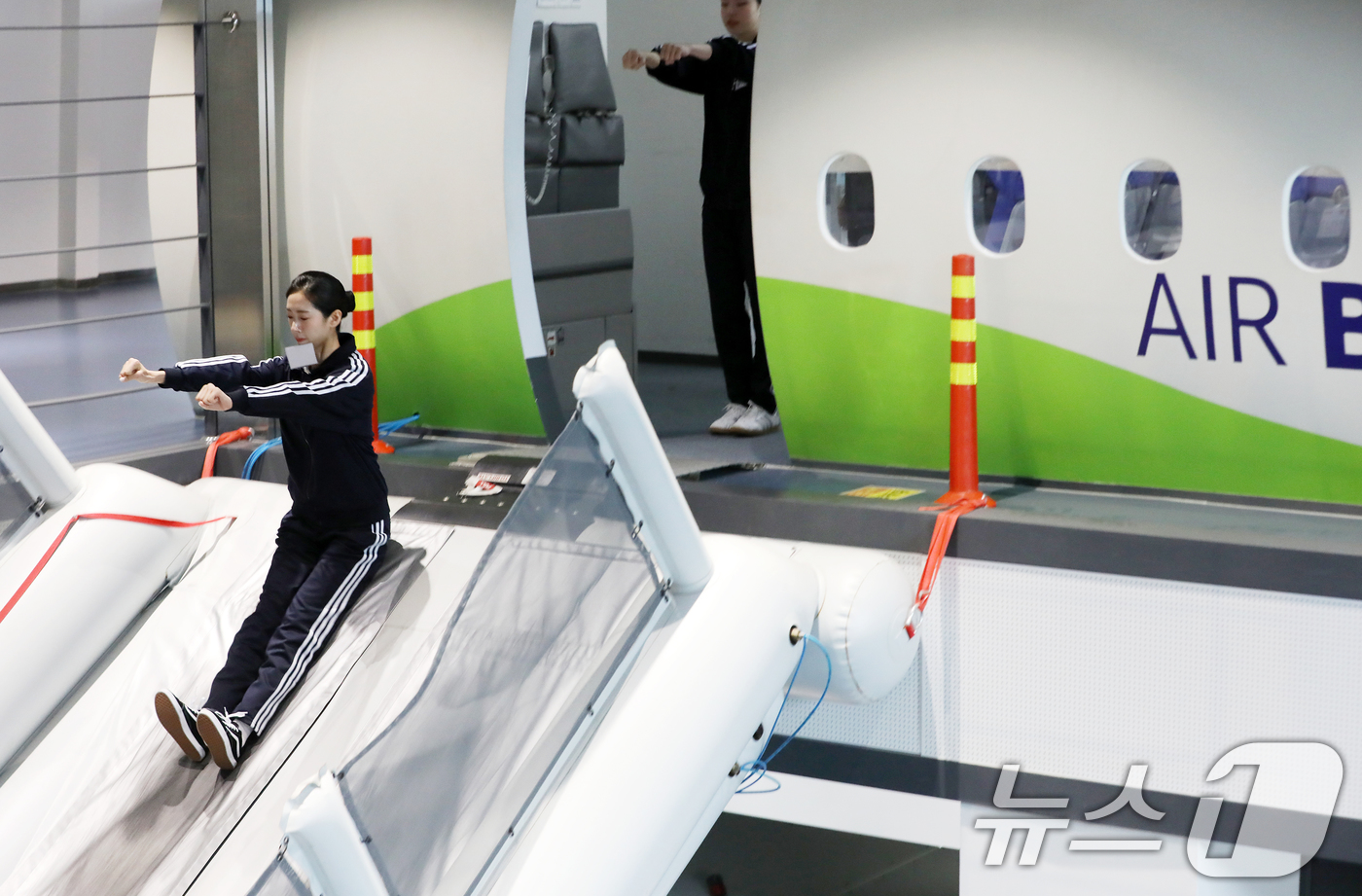 (부산=뉴스1) 윤일지 기자 = 12일 오전 부산 강서구 에어부산 사옥 내 훈련시설에서 신입 객실승무원들이 비상탈출 훈련을 하고 있다.지난달 입사한 신입 객실승무원 38명은 약 2 …