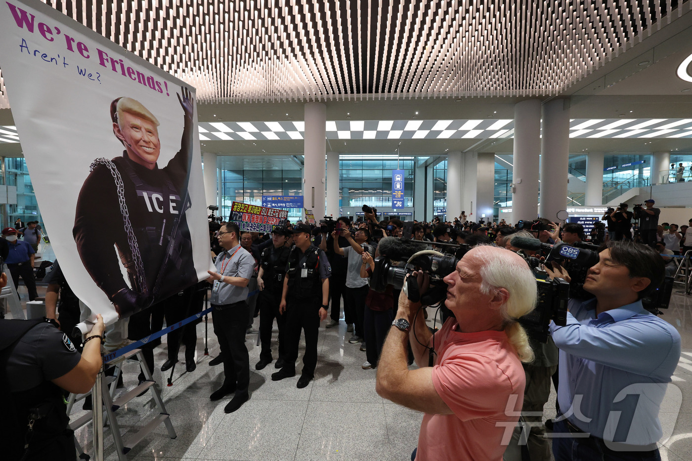 (인천공항=뉴스1) 박지혜 기자 = 미국 이민당국에 의해 조지아주에 구금됐던 한국인 근로자들이 귀국한 12일 인천국제공항 제2여객터미널 입국장에서 도널드 트럼프 미국대통령 얼굴 배 …