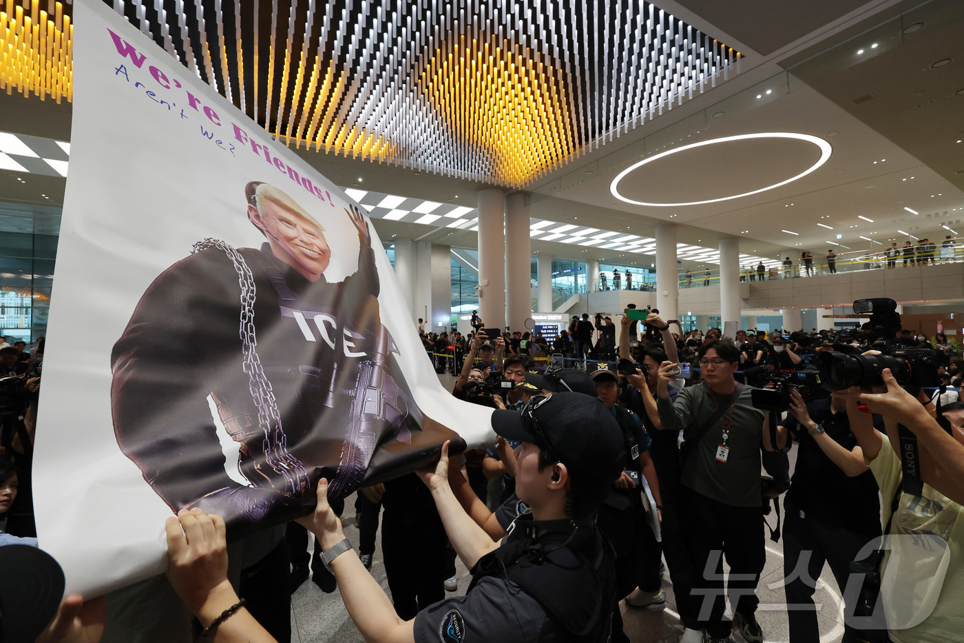 (인천공항=뉴스1) 박지혜 기자 = 미국 이민당국에 의해 조지아주에 구금됐던 한국인 근로자들이 귀국한 12일 인천국제공항 제2여객터미널 입국장에서 도널드 트럼프 미국대통령 얼굴 배 …