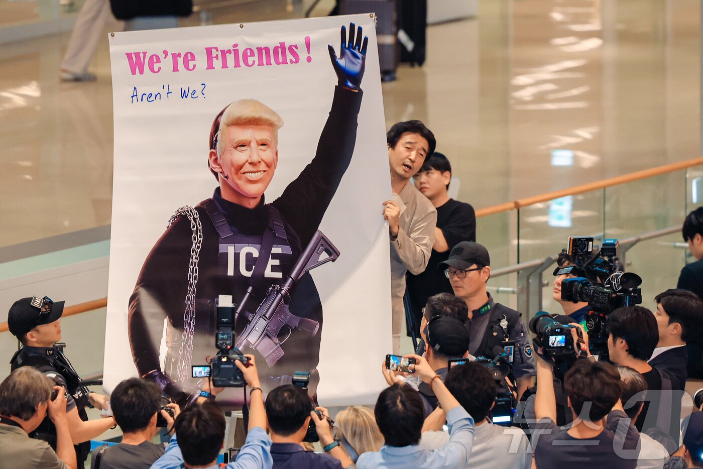 본문 이미지 - 미국 이민당국에 의해 체포·구금됐다 풀려난 한국인 316명이 탑승한 전세기가 인천국제공항 2터미널에 도착한 12일 이제석 이제석광고연구소 대표가 공항 입국장에서 트럼프 미국 대통령의 모습이 담긴 플래카드 퍼포먼스를 벌이고 있다. &#40;공동취재&#41;2025.9.12/뉴스1 ⓒ News1 박지혜 기자