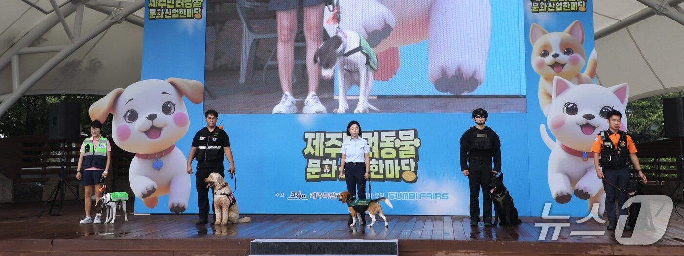 본문 이미지 - 13일 오전 제주시민복지타운에서 열린 '2025년 제주 반려동물 문화산업 한마당'에서 119구조견, 폭발물탐지견 등 사회 안전에 헌신한 봉사견들이 기념촬영을 하고 있다/뉴스1