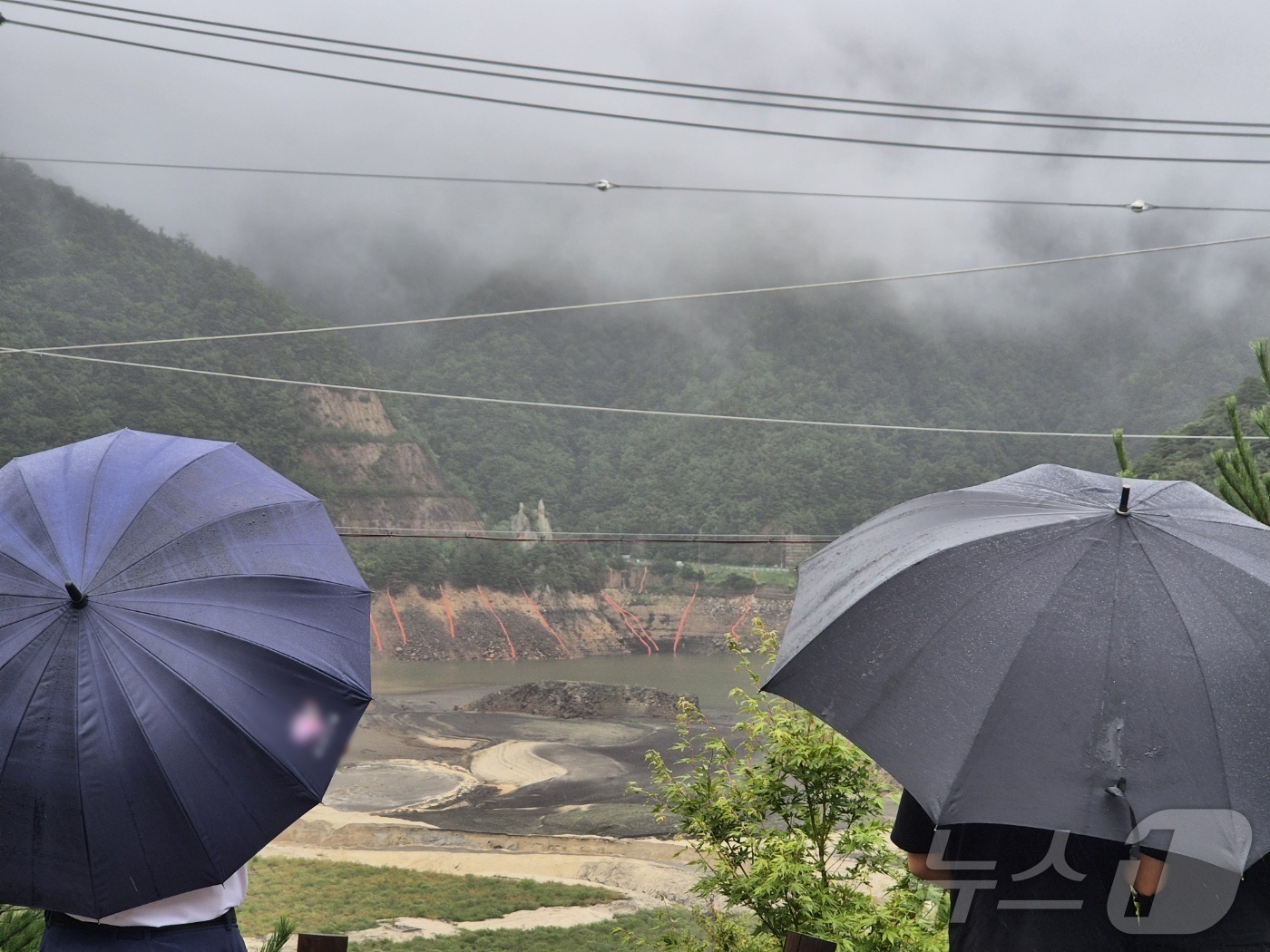 (강릉=뉴스1) 윤왕근 기자 = 극심한 가뭄을 겪고 있는 강원 강릉지역에 많은 비가 내린 13일 오전 우산을 쓴 시민이 마른 저수지에 내리는 단비를 바라보고 있다. 2025.9.1 …