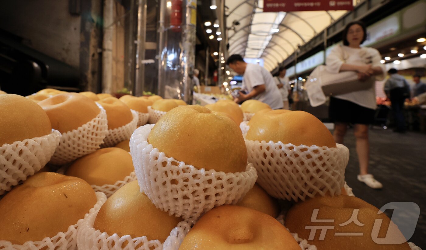 본문 이미지 - 14일 서울 동대문구 청량리 전통시장을 찾은 시민이 배를 구매하고 있다. 2025.9.14/뉴스1 ⓒ News1 김진환 기자