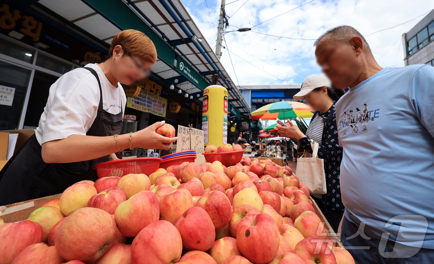 본문 이미지 - 14일 서울 동대문구 청량리 전통시장을 찾은 시민이 사과를 구매하고 있다. 2025.9.14/뉴스1 ⓒ News1 김진환 기자