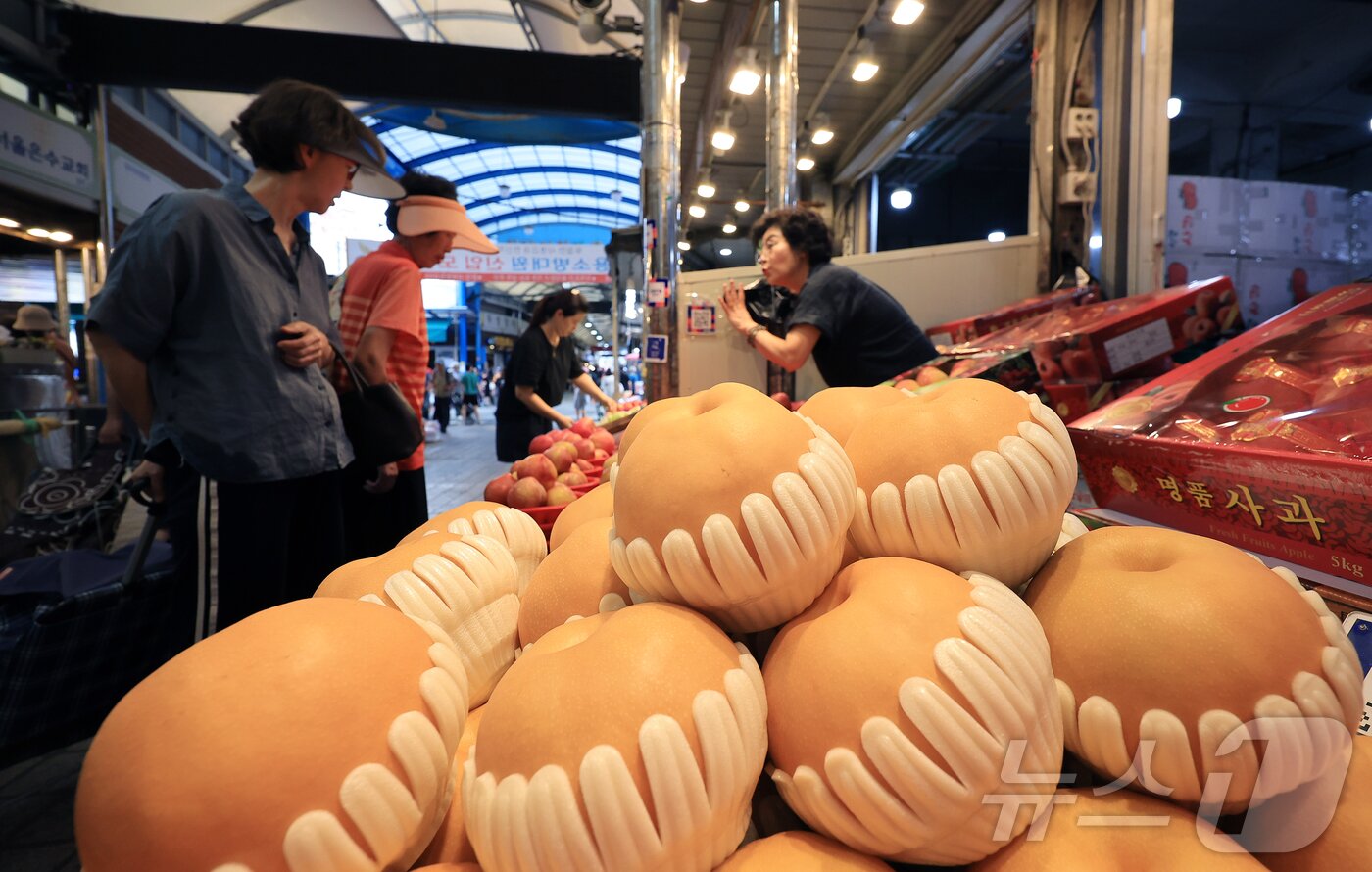 본문 이미지 - 14일 서울 동대문구 청량리 전통시장을 찾은 시민이 배를 구매하고 있다. 2025.9.14/뉴스1 ⓒ News1 김진환 기자