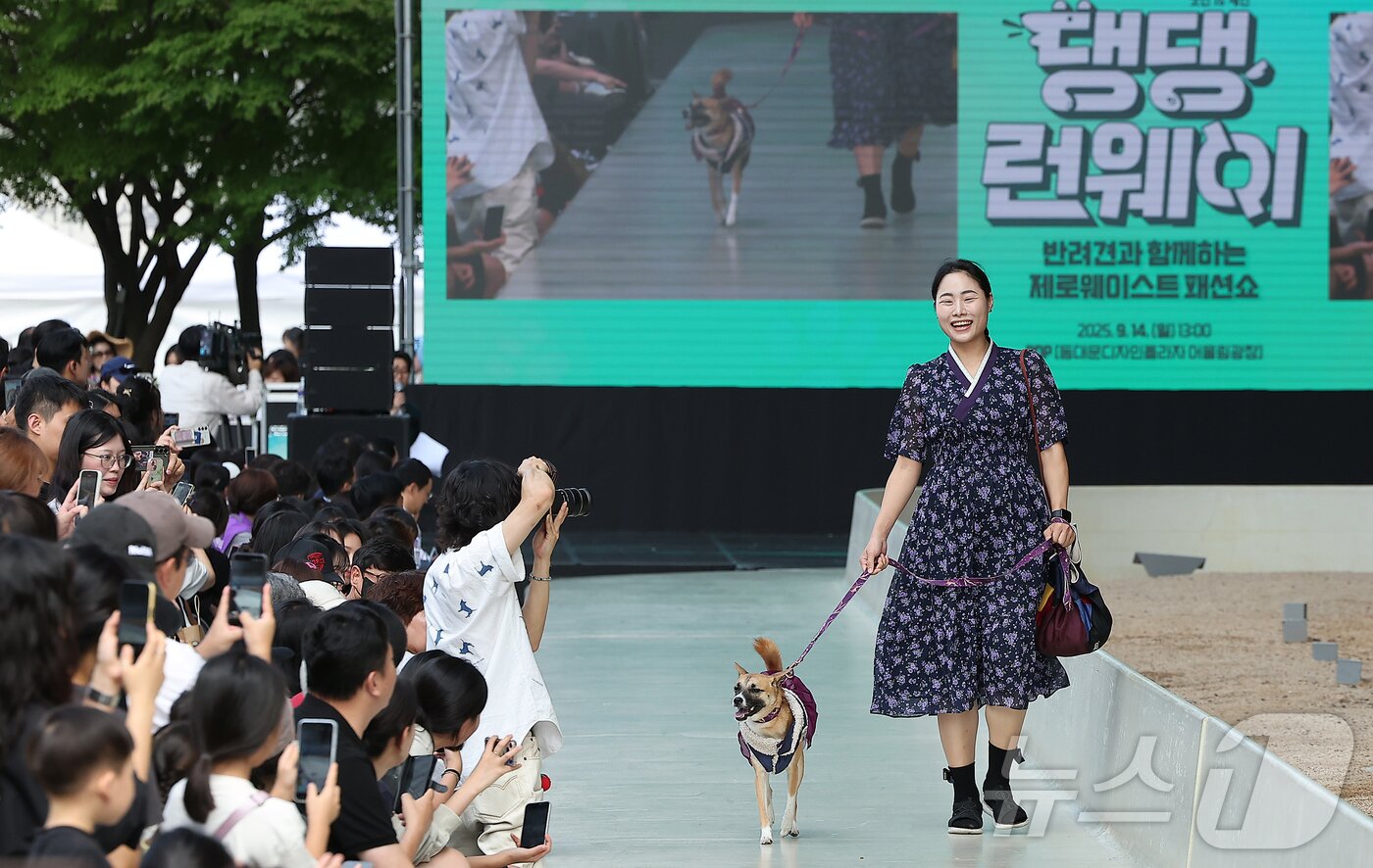 본문 이미지 - 14일 서울 중구 동대문디자인플라자(DDP)에서 열린 반려견과 함께하는 제로웨이스트 패션쇼 '댕댕 런웨이’에 참가한 모델들과 반려견들이 무대 위로 워킹하고 있다. 2025.9.14/뉴스1 ⓒ News1 김진환 기자