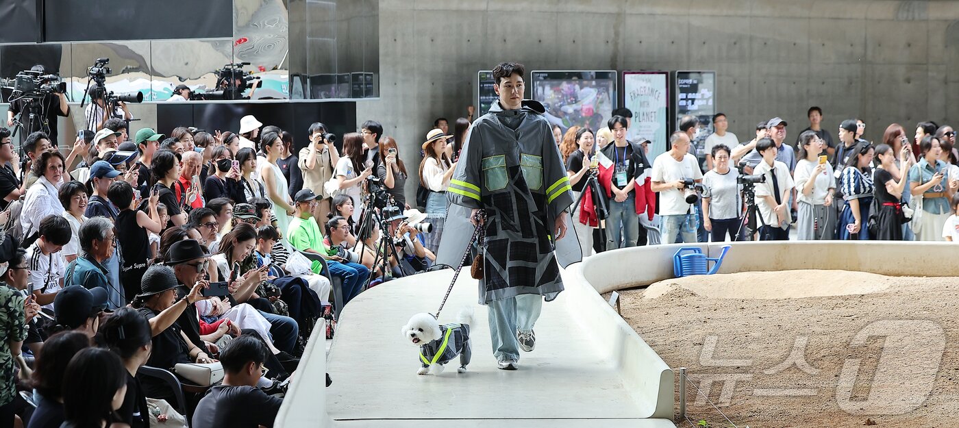 본문 이미지 - 14일 서울 중구 동대문디자인플라자(DDP)에서 열린 반려견과 함께하는 제로웨이스트 패션쇼 '댕댕 런웨이’에 참가한 모델들과 반려견들이 무대 위로 워킹하고 있다. 2025.9.14/뉴스1 ⓒ News1 김진환 기자