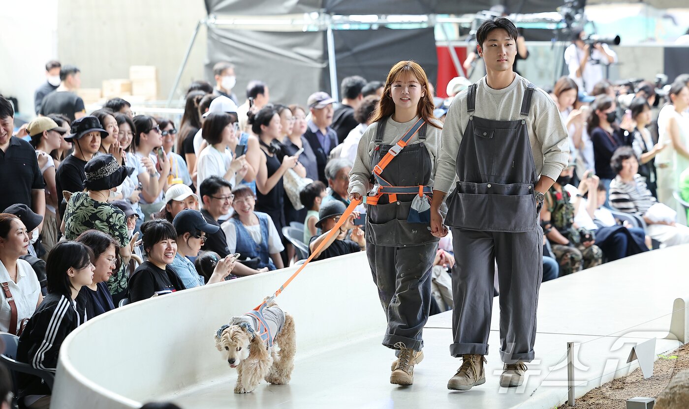 본문 이미지 - 14일 서울 중구 동대문디자인플라자(DDP)에서 열린 반려견과 함께하는 제로웨이스트 패션쇼 '댕댕 런웨이’에 참가한 모델들과 반려견들이 무대 위로 워킹하고 있다. 2025.9.14/뉴스1 ⓒ News1 김진환 기자