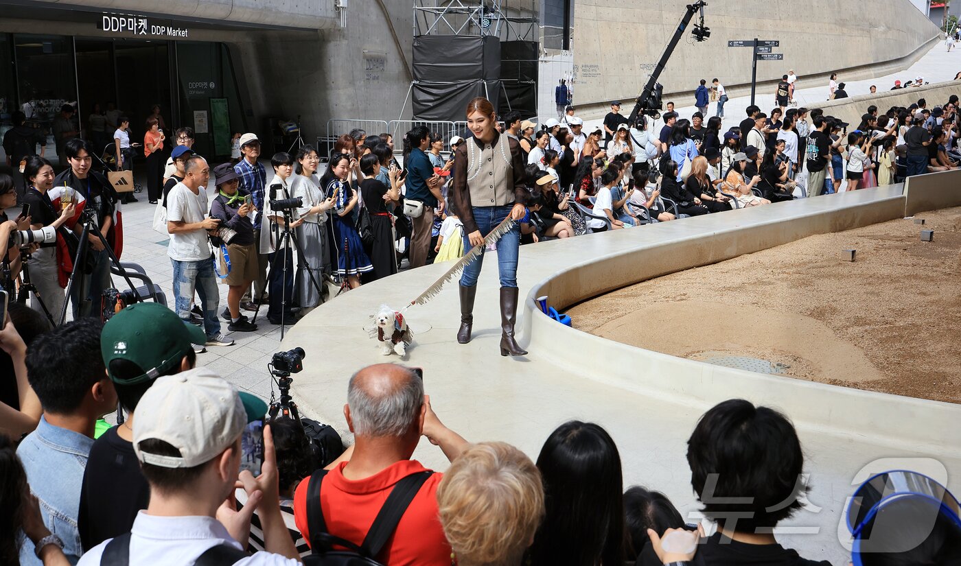 본문 이미지 - 14일 서울 중구 동대문디자인플라자(DDP)에서 열린 반려견과 함께하는 제로웨이스트 패션쇼 '댕댕 런웨이’에 참가한 모델들과 반려견들이 무대 위로 워킹하고 있다. 2025.9.14/뉴스1 ⓒ News1 김진환 기자